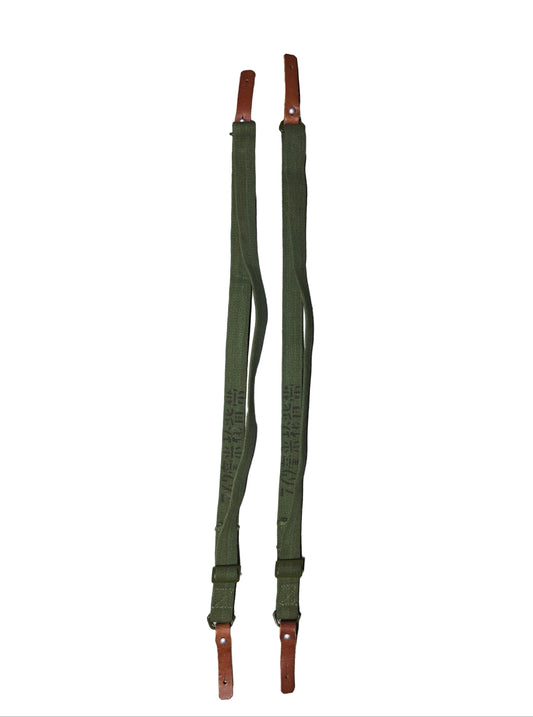 Two type 56 chinese sks green straps with brown ends on a gray surface.