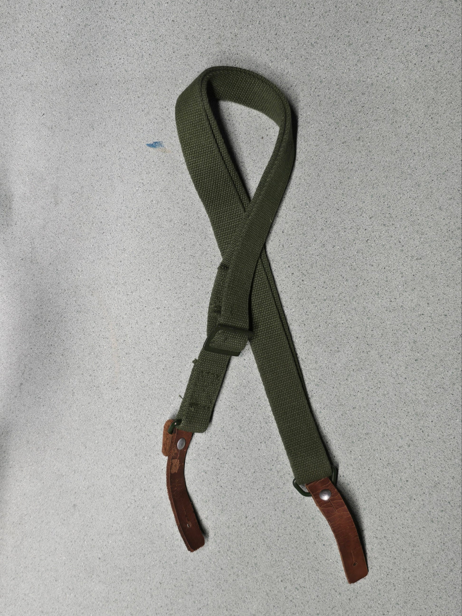Green belt with brown leather ends on a gray background