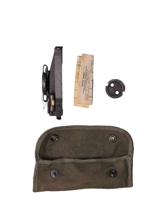 U.S. M15 Grenade Launcher sight, Weapon components including a magazine, clip, and paper on a gray surface