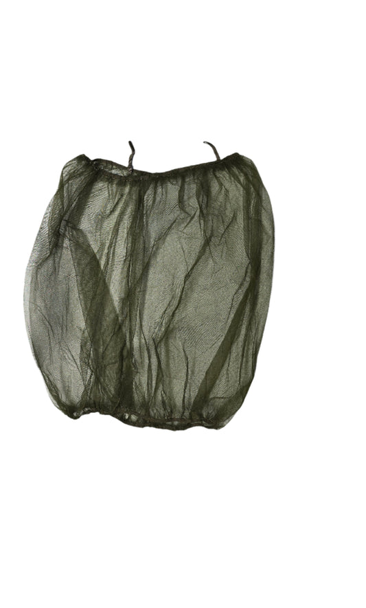Green mesh bag on a light gray surface with various items in the background